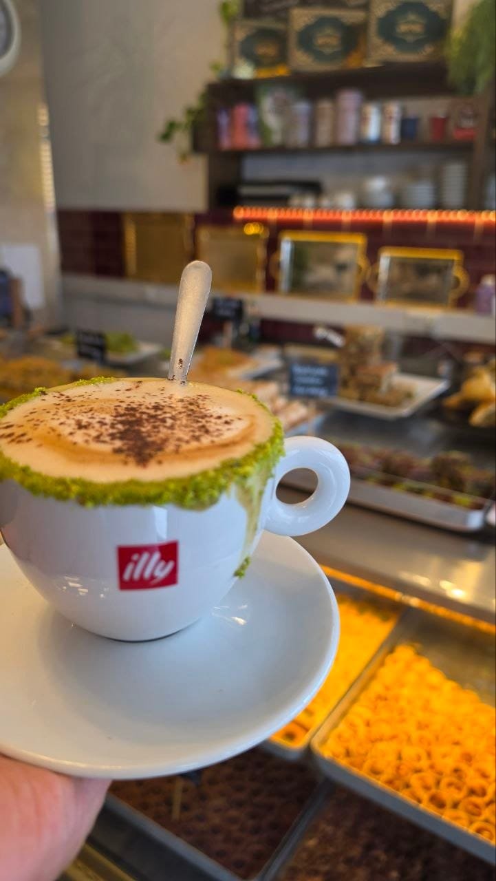 Cappuccino mit Pistazienrand in einer Illy-Tasse