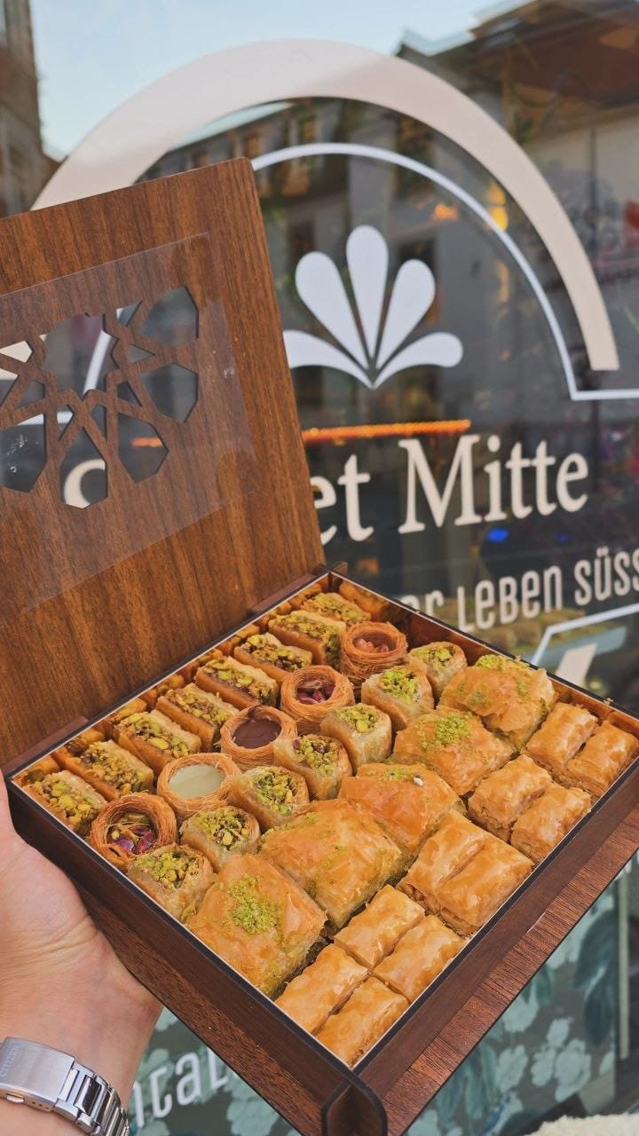 Geschenkbox aus Holz mit gemischtem Baklava vor dem Sweet-Mitte-Logo