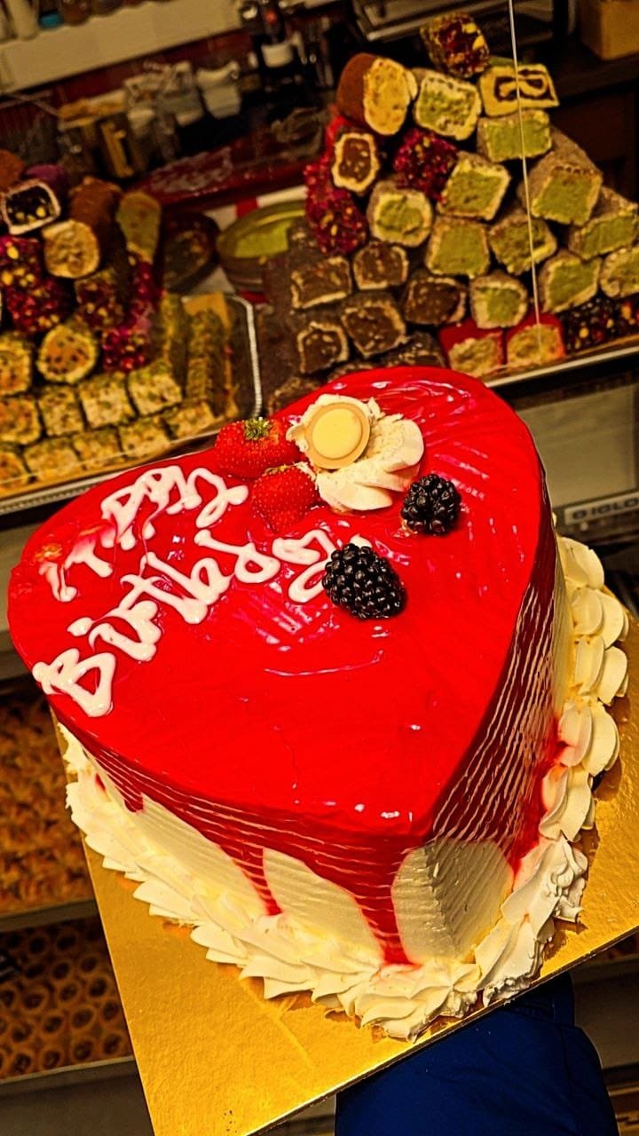 Rote Herztorte mit Beeren und Happy-Birthday-Schriftzug